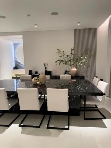 Black marble dining table with 8 white cantilever chairs