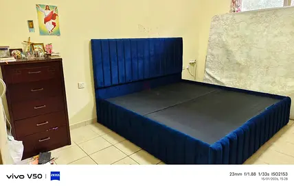 Blue velvet upholstered bed frame with tall headboard