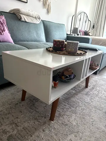 White coffee table with storage cubbies and wooden legs