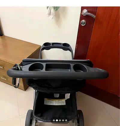 My black standard stroller with parent and child trays and cup holders