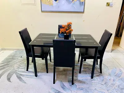 4-seater glass dining table with black faux-leather chairs (used)