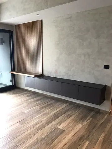 Floating wall-mounted TV console with wood slat accent panel