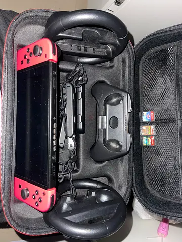 Nintendo Switch with neon pink Joy-Cons, 2 steering wheels and 3 games and its bag