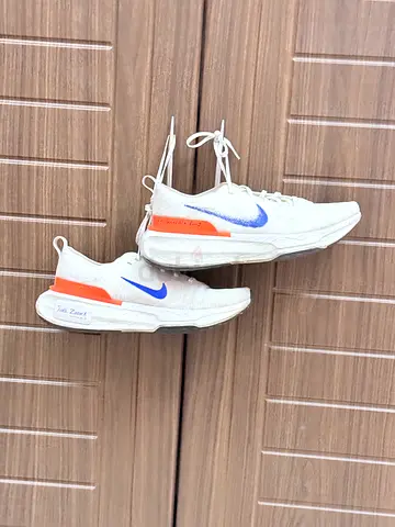 My white Nike running shoes with blue swoosh — lightly used