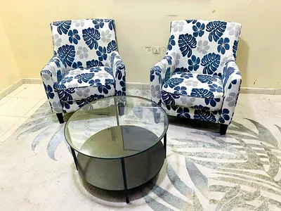 Pair of floral-pattern armchairs with round glass coffee table