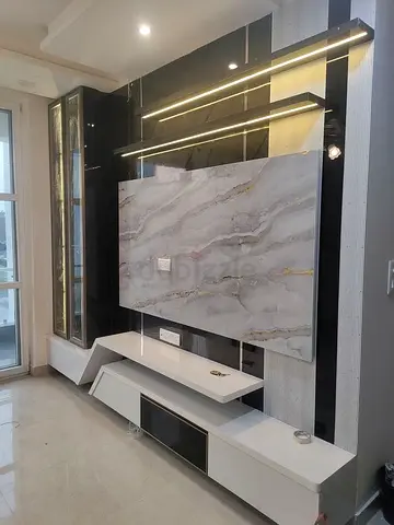 Modern TV entertainment center with marble-effect panel and LED shelves