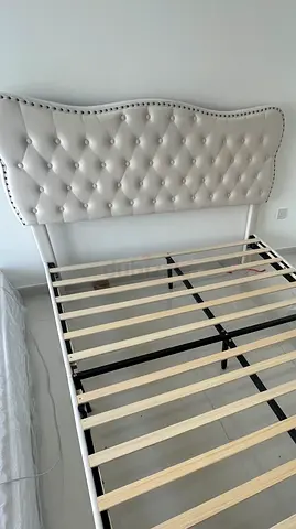 White tufted upholstered bed frame with padded headboard