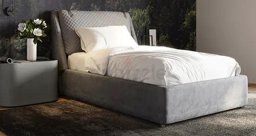 Grey velvet upholstered bed with padded headboard