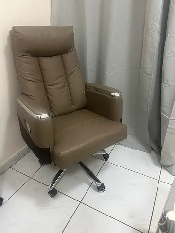 Comfortable brown leather swivel office chair with footrest