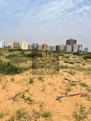 Corner residential & commercial land for sale in Al Alia – Ajman, 15,495 sq.ft, G+23 permit with apartments, freehold, AED 7,700,000.
