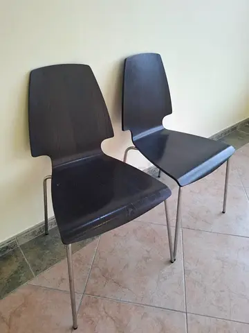 Pair of dark wood dining chairs with metal legs