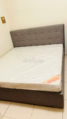 Grey upholstered bed frame with headboard and mattress