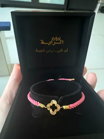 Al Raya Gold-tone clover charm pink cord bracelet in gift box