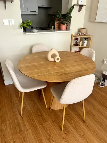 Round wooden dining table with 3 cream boucle chairs