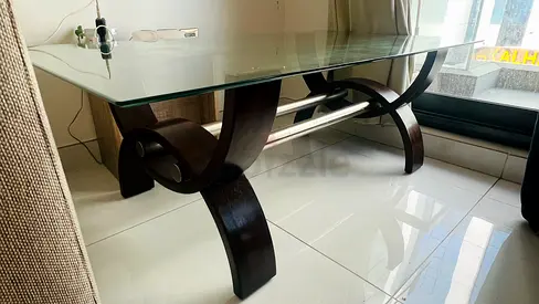 Glass coffee table with curved wooden base - good condition