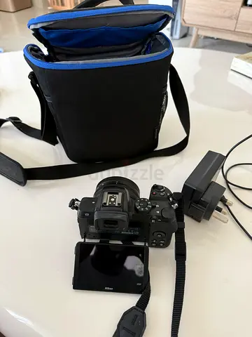 Nikon z50 mirrorless camera kit — camera body with flip screen, charger, strap and bag