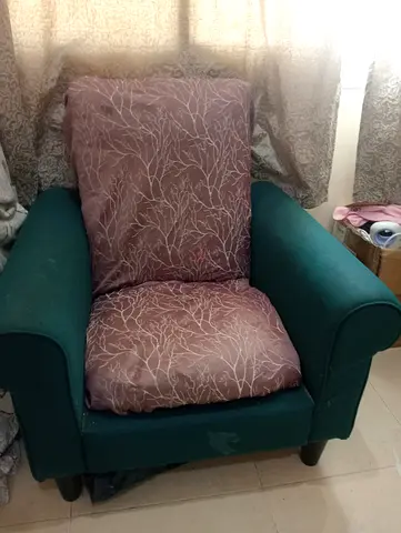 Green fabric armchair with removable patterned cushions