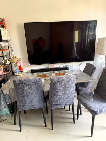 4-seater glass dining table with grey upholstered chairs with chair covers