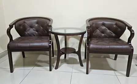 Pair of brown leather-look accent chairs with glass-top side table