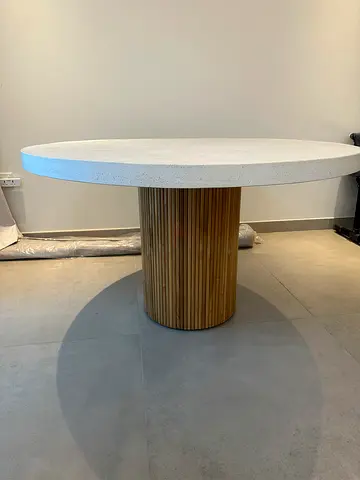 Round dining table with white stone top and fluted wooden base