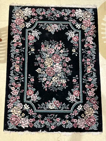 Black floral area rug with vintage rose motif - good condition