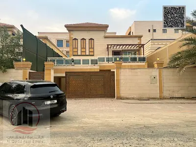 Villa for sale in Ajman, Al Muwaihat area. 5 master bedrooms, majlis, 2 living rooms, and a maid's room. Freehold ownership for all nationalities. Ban