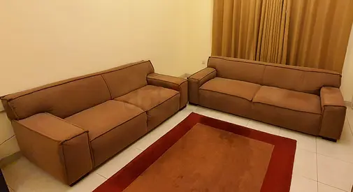 Pair of brown fabric 3-seater sofas and table — good condition