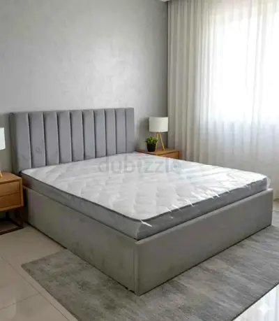 Grey upholstered double bed with storage