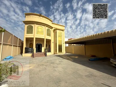 Villa for sale in Ajman, Al Muwaihat area. 5 master bedrooms, majlis, 2 living rooms, and a maid's room. Freehold ownership for all nationalities. Ban