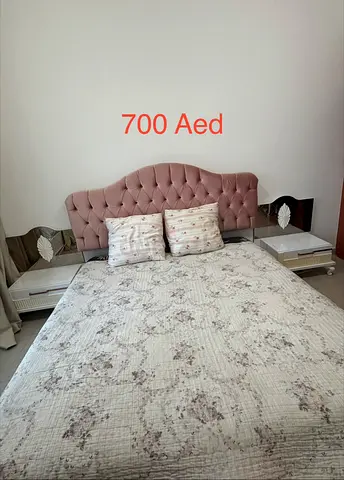 Queen bed with upholstered headboard and matching bedside tables - 700 AED