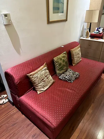 Red three seater sofa / futon in good condition