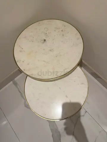 Pair of round marble-top nesting side tables with brass trim