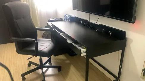 Black writing/ computer desk with pull-out keyboard drawer and cable management.