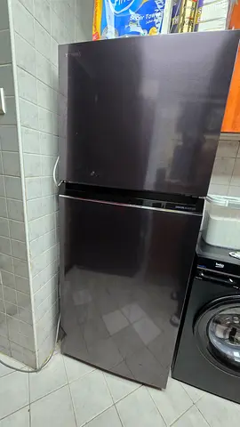 Toshiba Two-door refrigerator in good condition — top freezer, dark finish.