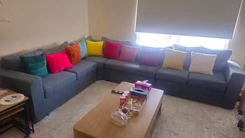 Grey L-shaped Fabric Corner Sofa with Colorful Cushions - Good Condition
