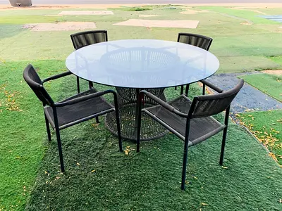 Outdoor round glass-top dining table with 4 black wicker chairs