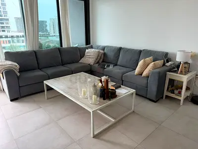 Large L-shaped Blue /Grey Fabric Corner Sofa — Good Condition + (PLUS)  large table (white)