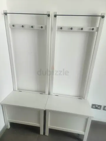 Pair of white hallway bench coat racks with hooks and storage
