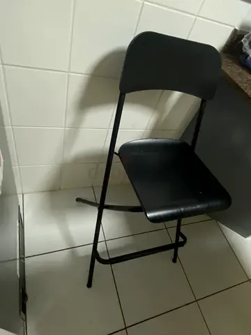 Compact black metal folding chair — sturdy, used