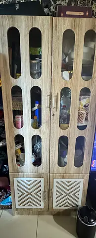 Tall wooden storage cabinet with glass-panel doors — good used condition