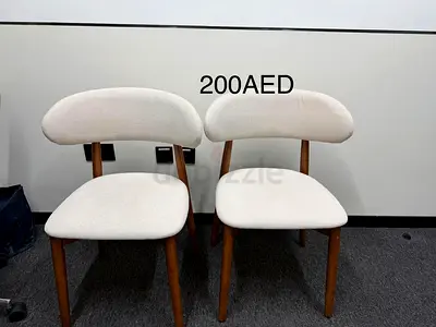 Pair of modern white fabric dining chairs with wooden legs - 200 AED