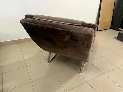 Brown velvet recliner sofa with ribbed upholstery and a metal frame from Home Centre