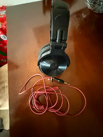 Used over-ear wired headphones with coiled pink cable