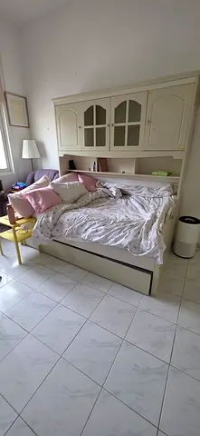 White wooden single bed with headboard and storage