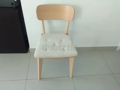 Light wood dining chairs with cushioned seat.