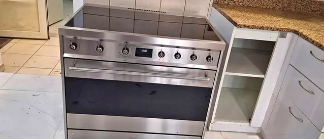 Smeg stainless steel cooker with an induction hob, specifically model C9IMX2.