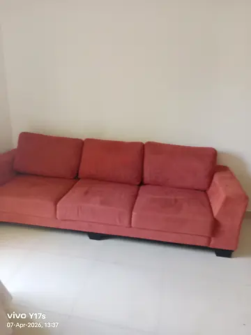 Three-seater coral fabric sofa in good condition