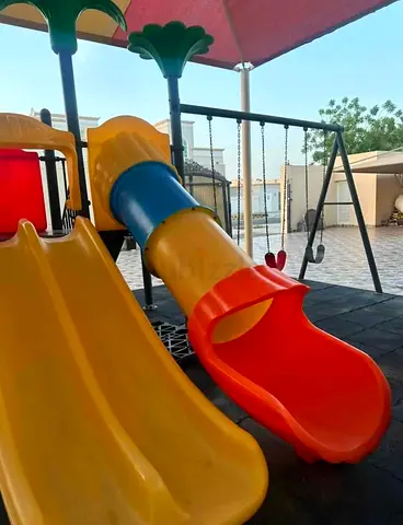 Outdoor kids playset with double slides and climbing platform