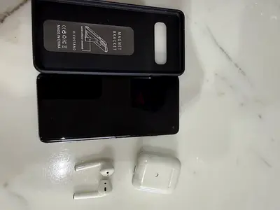 Samsung Galaxy S10 (black) with case and wireless earbuds