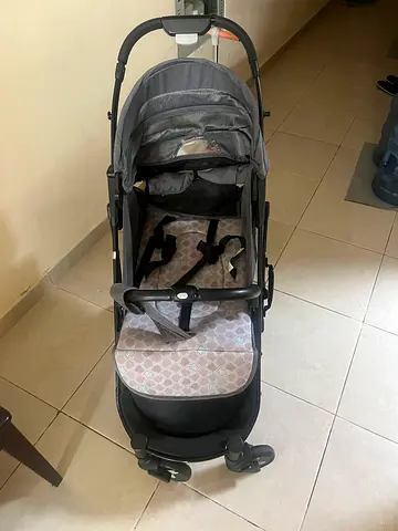 Lightly used grey standard baby stroller with reclining seat and storage basket